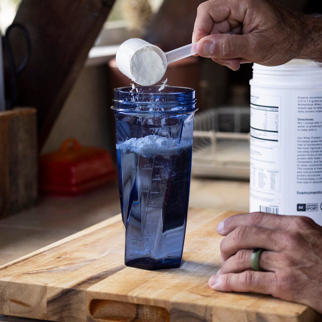 Protein powder being poured into a YETI Yonder Shaker Bottle in Navy.